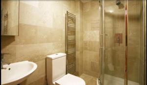 a bathroom with a toilet and a sink and a shower at Central London Rooms in London