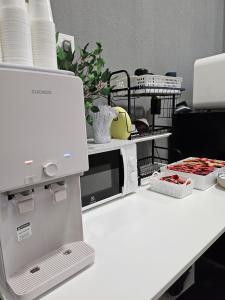 a white counter with a microwave on a table at le melur guest house in George Town