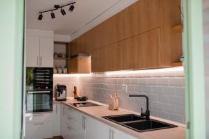 una cocina con encimeras blancas y armarios de madera en Casa Izvoarele, en Izvoarele