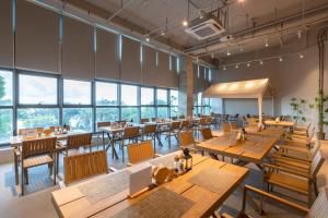 a restaurant with wooden tables and chairs and large windows at Platinum Century Hotel in Huizhou