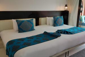 a large bed with blue and white sheets and pillows at Marrakesh Hua Hin Resort & Spa in Hua Hin