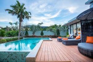 a swimming pool with a wooden deck next to a house at Wonderland Suites and Resort in Sihanoukville