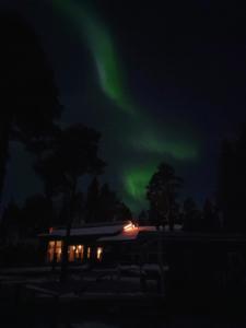 un'immagine dell'aurora boreale nel cielo sopra una casa di Chalet Norva a Rovaniemi