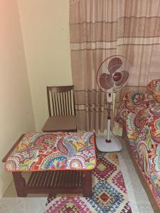 um quarto com uma cama, uma ventoinha e uma cadeira em awesome stay em Nadi