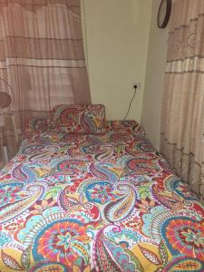 a bed with a colorful blanket on top of it at awesome stay in Nadi