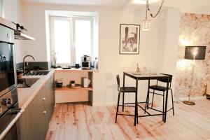 uma cozinha com mesa e cadeiras num quarto em La Sublime Love House em Briey