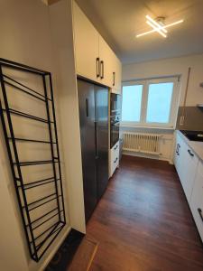 a kitchen with a black refrigerator and wooden floors at Pimp My TLA - TDY in Mackenbach