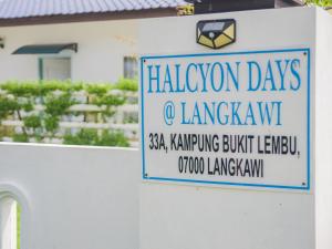 una señal para los días de alagonia o la ciudad de la lengua en un edificio en Halcyon Days @ Langkawi, en Pantai Cenang