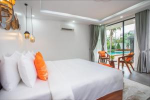 um quarto com uma cama branca e uma varanda em Wonderland Suites and Resort em Sihanoukville