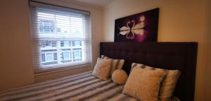 a bedroom with a bed with a window at Central London Rooms in London
