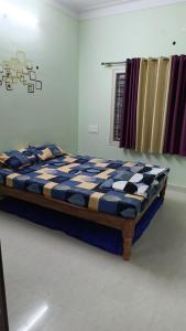 a bed in a room with a blue and white at Galaxy Villa's Homestay 8431o31389 in Mysore