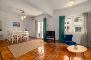 a living room with a table and chairs and a television at Spacious 2bd apartment next to Athens Archeological museum in Athens