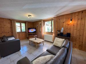 a living room with a couch and a tv at Perfect Mountain Condo - 4 Valleys - Swiss Alps in Beuson