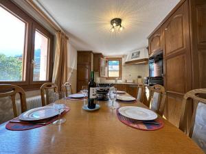 a kitchen with a table with a bottle of wine at Perfect Mountain Condo - 4 Valleys - Swiss Alps in Beuson +15 photos