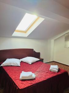 1 dormitorio con 1 cama con 2 toallas en Hotel Flora, en Drobeta-Turnu Severin