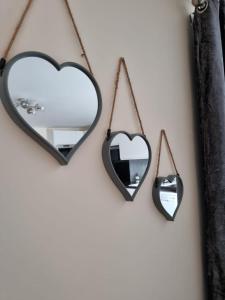two hearts and two mirrors hanging on a wall at Ground Floor 1 Bedroom Apt With Parking, Edge of Glastonbury and Street in Street