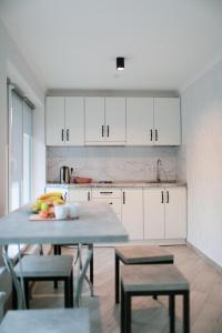 a kitchen with white cabinets and a table and chairs at Gallery Elit Hotel in Dunaivtsi