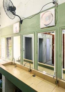 a bathroom with three sinks and a mirror at Bestow Capsule Hostel in Kuala Lumpur