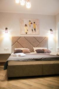 a bedroom with a bed with two paintings on the wall at Gallery Elit Hotel in Dunaivtsi