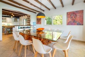 a kitchen with a glass table and white chairs at Can Taika in Port des Torrent