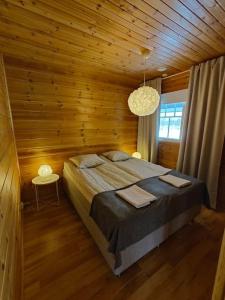 a bedroom with a bed in a wooden room at Twin Peaks Urupää B Saariselkä in Saariselka