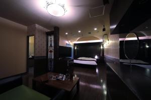 四日市的住宿－Hotel Mio Plaza (Adult Only)，一间客房内配有床和桌子的房间