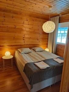a bedroom with a bed and a wooden wall at Twin Peaks Urupää B Saariselkä in Saariselka