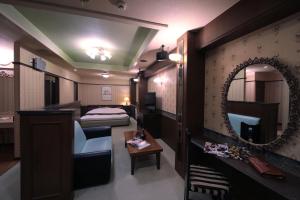 四日市市にあるホテルミオプラザ(大人専用)のベッドと鏡が備わるホテルルーム