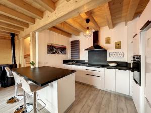 a kitchen with white cabinets and a black counter top at Chalet Le Vallonnet in La Toussuire