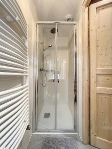 eine Dusche im Bad mit einer Duschkabine aus Glas in der Unterkunft Chalet Le Vallonnet in La Toussuire