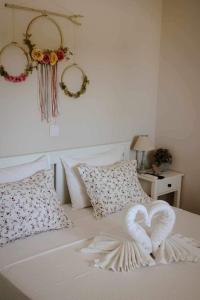 a bed with two heart towels on it at Philia Apartment in Artemida