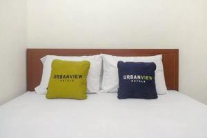 two pillows sitting on top of a bed at Urbanview Grand Lotus Hotel by RedDoorz in Purwokerto