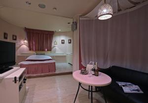 a bedroom with a bed and a table and a couch at Hotel Mio Seki Adult Only in Mukumoto