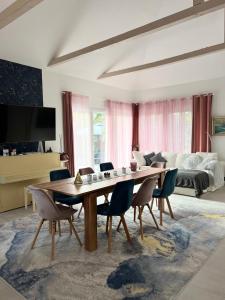 uma sala de estar com uma grande mesa de madeira e cadeiras em The Private House em Siófok