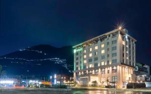 a hotel at night with a mountain in the background at Holiday Inn Katra Vaishno Devi, an IHG Hotel in Katra