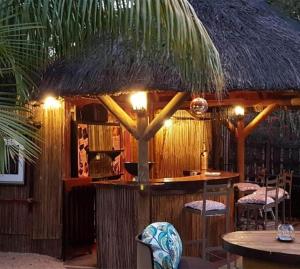 a bar with a straw hut with tables and chairs at VILLAVAGUE Lodge in Albion
