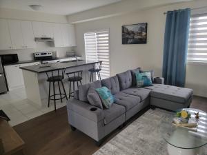 a living room with a couch and a kitchen at Chorburjo Cozy Villa - Deluxe Room in Penetanguishene