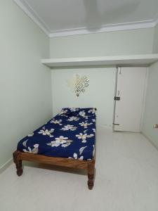 Cama en habitación con manta azul y flores en Single haven 8431o31389 en Mysore