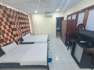 Habitación con 2 camas y TV de pantalla plana. en Thanh Nien Guest House en Ho Chi Minh