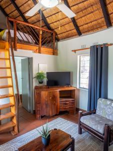 a living room with a couch and a television at Olifants River Lodge by Dream Resorts in Middelburg