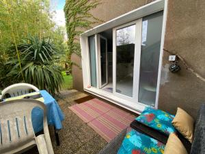 a patio with a window and a table and chairs at Studio dans maison avec parking in Bouguenais