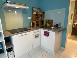 Studio dans maison avec parking في بوغينايس: مطبخ مع دواليب بيضاء ومغسلة