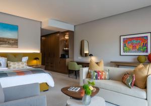una camera d'albergo con letto e divano di The Hazendal Hotel by NEWMARK a Stellenbosch