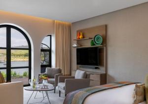 a hotel room with a bed and a tv at The Hazendal Hotel by NEWMARK in Stellenbosch