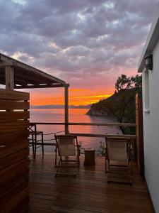 een terras met stoelen en uitzicht op de zonsondergang bij Skopelos Aerino house in Skopelos Town