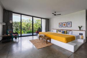 1 dormitorio con cama grande y ventana grande en Open House by StayVista - Nestled in nature, featuring a Swimming pool & Expansive lawn for a serene retreat, en Shikrapur