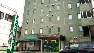 青森的住宿－Aomori Green Park Hotel Annex，前面有停车位的建筑