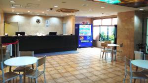 Aomori Green Park Hotel Annex في أوموري: مطعم بطاولات وكراسي وآلة شرب