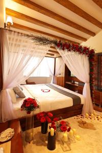 a bedroom with a bed with red flowers on the floor at Green Wood Hill Cottage in Ooty