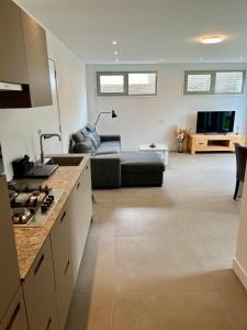 een keuken en een woonkamer met een bank en een tafel bij Appartement Huis op het Duin in Egmond aan Zee